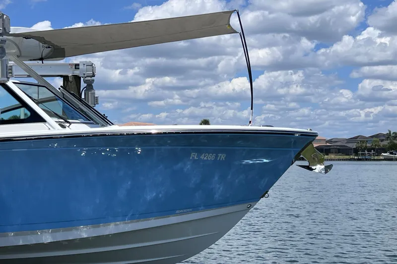 Slide: The Image of 2023 Blackfin 272 DC boat on water, blue hull, sunny day, clouds in sky. - 85