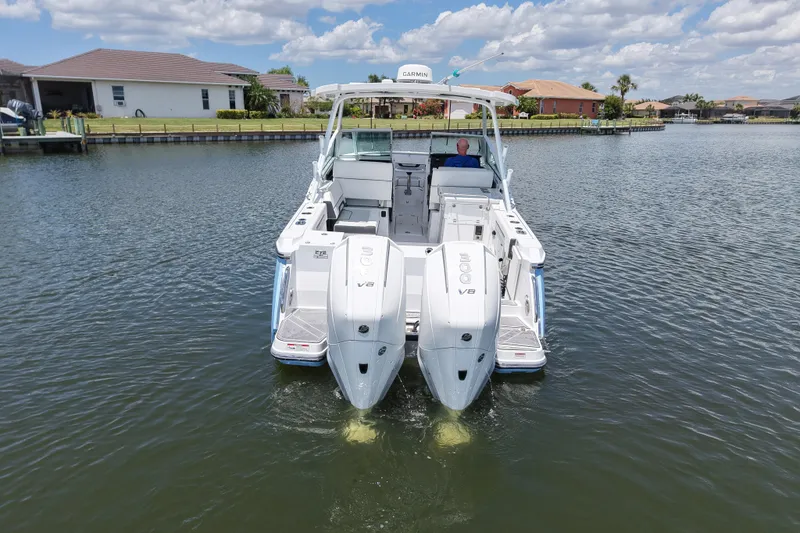 Slide: The Image of 2023 Blackfin 272 DC boat on water, featuring dual V8 engines, under a partly cloudy sky. - 9