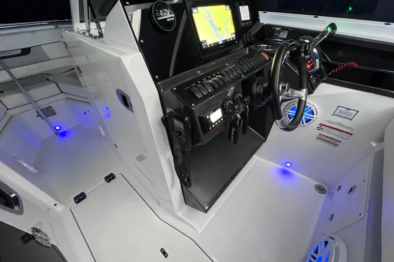 Slide: The Image of 2023 Blackfin 272 DC boat cockpit with illuminated controls and navigation system. - 90