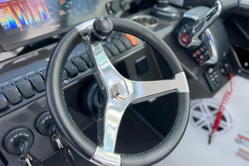Slide: The Image of 2023 Blackfin 272 DC boat dashboard with steering wheel and control panel. - 92
