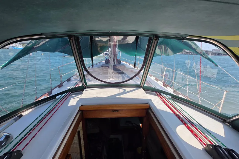 Slide: The Image of 1987 Gozzard 36 Cruiser sailboat cockpit view with canopy and ocean backdrop. - 22