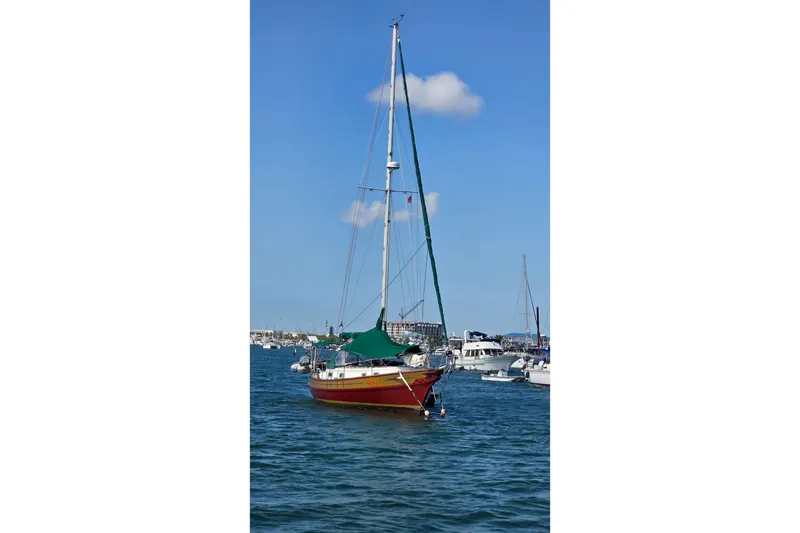 Slide: The Image of 1987 Gozzard 36 Cruiser sailboat anchored in a marina under a clear blue sky. - 3