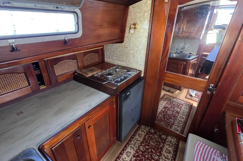 Slide: The Image of Interior of 1987 Gozzard 36 Cruiser with wooden cabinetry and compact kitchen area. - 35