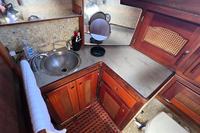 Slide: The Image of Interior of 1987 Gozzard 36 Cruiser bathroom with sink, mirror, and wooden cabinetry. - 36