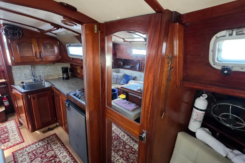 Slide: The Image of Interior of 1987 Gozzard 36 Cruiser yacht with wooden cabinetry and cozy seating area. - 38