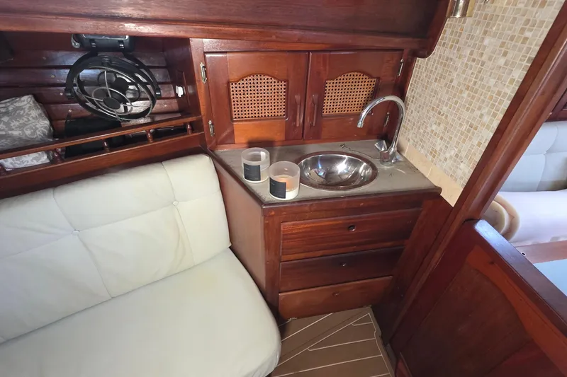 Slide: The Image of Cozy interior of 1987 Gozzard 36 Cruiser with wooden cabinetry and compact sink area. - 39