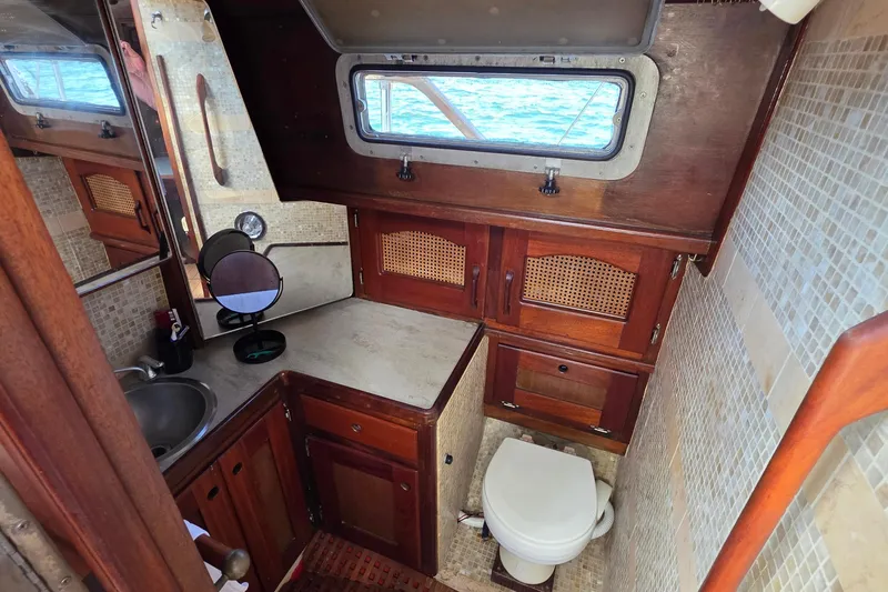 Slide: The Image of Interior of 1987 Gozzard 36 Cruiser bathroom with wooden cabinetry and nautical decor. - 44