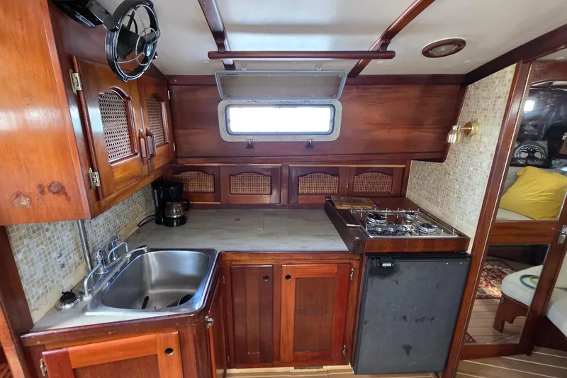 Slide: The Image of 1987 Gozzard 36 Cruiser galley with wood cabinetry, stove, sink, and window. - 48