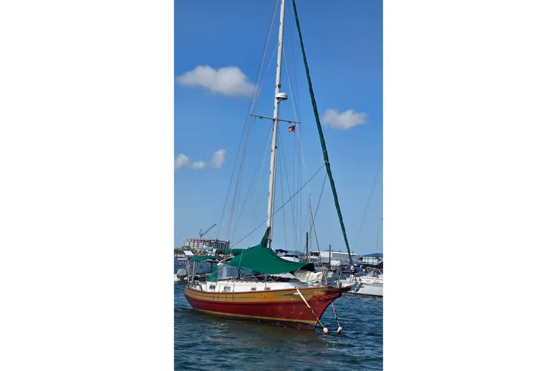 Slide: The Image of 1987 Gozzard 36 Cruiser sailboat anchored in a marina under a clear blue sky. - 5