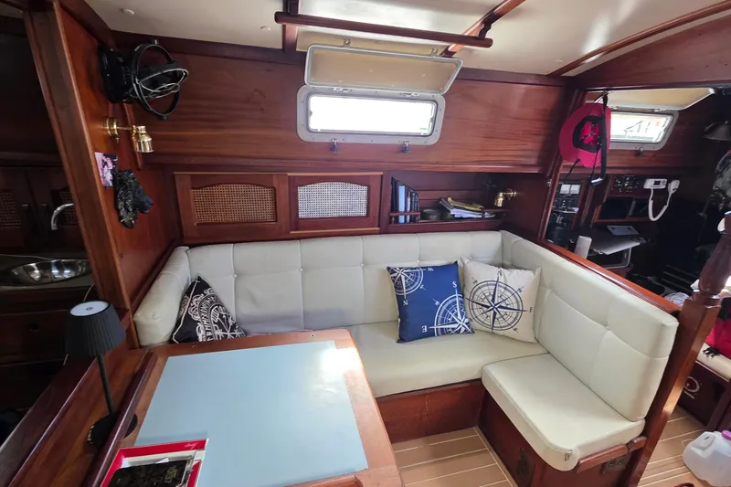 Slide: The Image of Cozy interior of 1987 Gozzard 36 Cruiser with cushioned seating and nautical-themed pillows. - 50