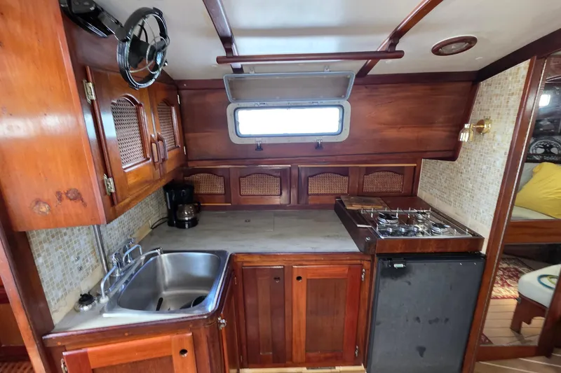 Slide: The Image of 1987 Gozzard 36 Cruiser kitchen with wooden cabinetry, sink, stove, and window. - 51