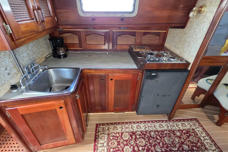 Slide: The Image of Galley kitchen in 1987 Gozzard 36 Cruiser with wood cabinetry and compact appliances. - 54