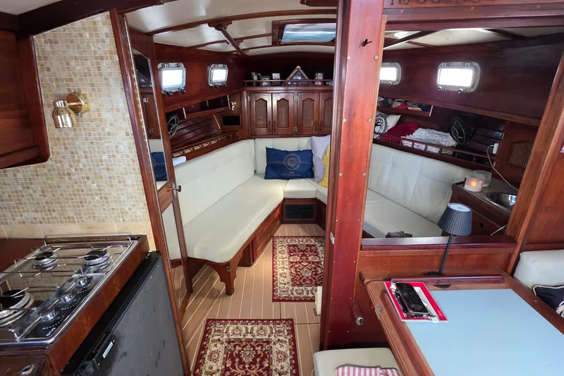 Slide: The Image of Interior of a 1987 Gozzard 36 Cruiser yacht with cozy seating and wooden finishes. - 57