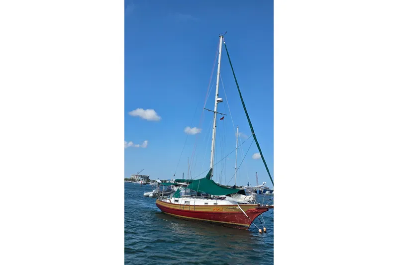 Slide: The Image of 1987 Gozzard 36 Cruiser sailboat anchored in calm waters under a clear blue sky. - 6