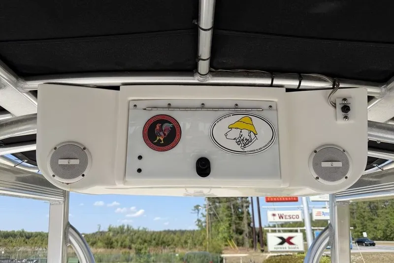 Slide: The Image of 2015 Sea Hunt Ultra 211 boat console with speakers and decorative stickers. - 13