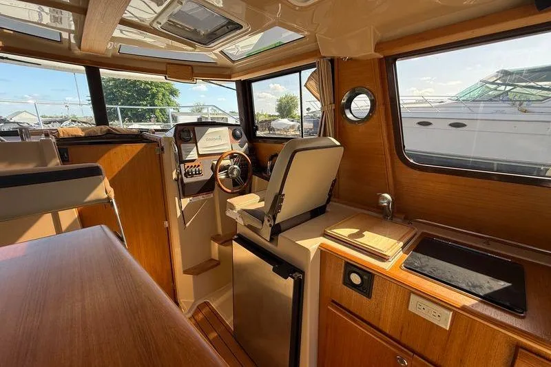 Slide: The Image of Interior of 2019 Ranger Tugs R-23 boat with helm, seating, and kitchenette. - 10