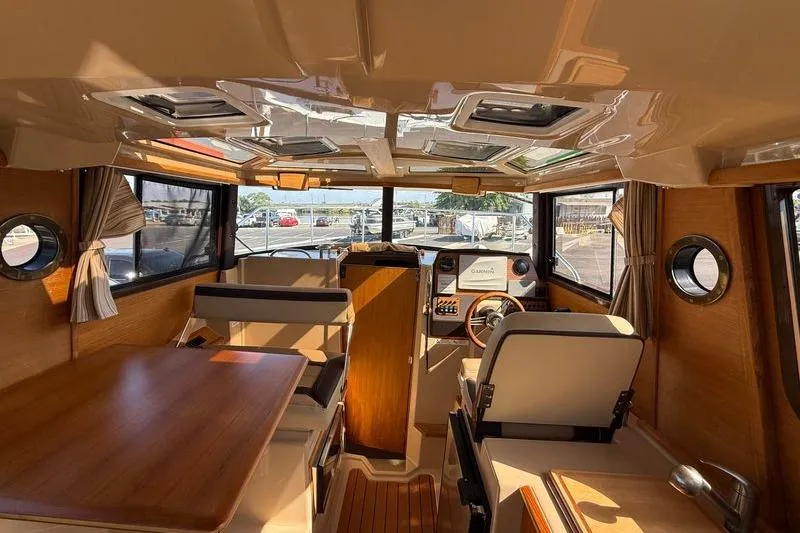 Slide: The Image of Interior of 2019 Ranger Tugs R-23 boat, featuring wood accents and spacious seating. - 13