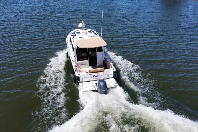 Slide: The Image of 2019 Ranger Tugs R-23 boat cruising on open water, rear view. - 3