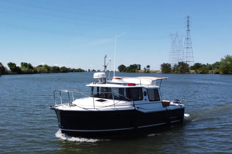 Slide: The Image of 2019 Ranger Tugs R-23 cruising on a scenic river with clear blue skies. - 4