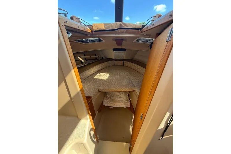 Slide: The Image of 2019 Ranger Tugs R-23 cabin interior with cozy bed and wooden accents. - 5