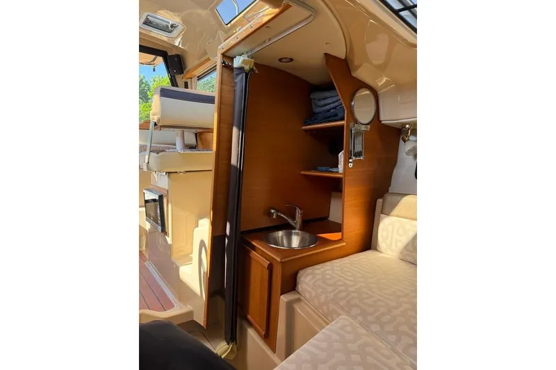 Slide: The Image of 2019 Ranger Tugs R-23 interior with compact sink, shelves, and seating area. - 6