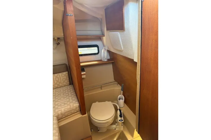 Slide: The Image of 2019 Ranger Tugs R-23 boat interior with compact bathroom and wooden accents. - 7