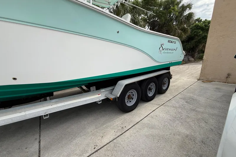 Slide: The Image of 2013 Sea Fox 286 Center Console boat on a triple-axle trailer, parked outdoors. - 4