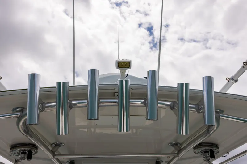 Slide: The Image of Rod holders on a 2011 Jupiter 26 FS boat against a cloudy sky. - 23