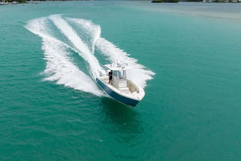 Slide: The Image of A 2011 Jupiter 26 FS boat cruising on turquoise waters, leaving a wake trail. - 31