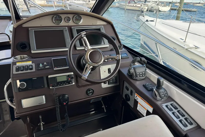 Slide: The Image of Cockpit of 2015 Regal 42 Sport Coupe with steering wheel and navigation controls. - 14
