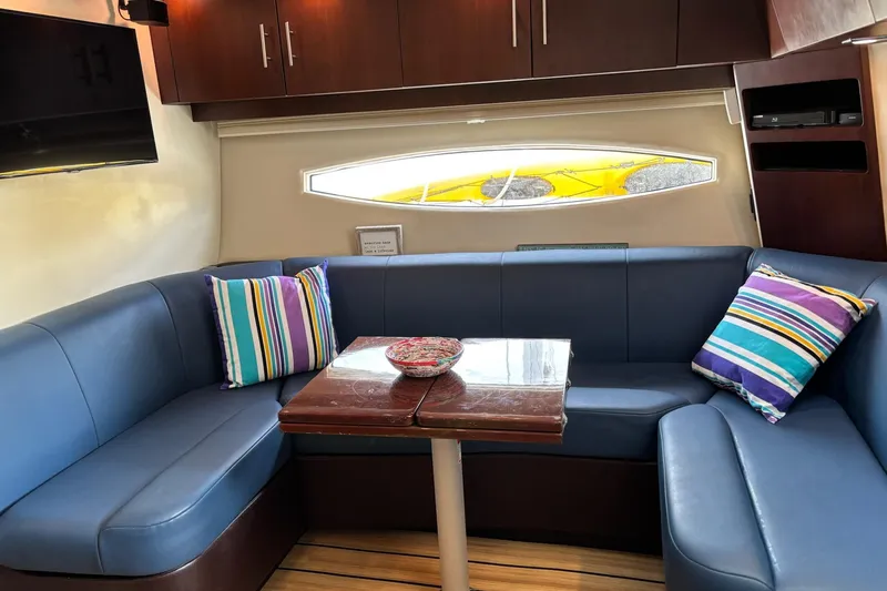 Slide: The Image of Interior of 2015 Regal 42 Sport Coupe with blue seating and colorful striped pillows. - 17
