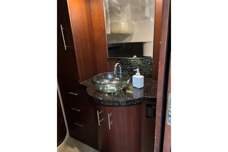 Slide: The Image of Luxurious bathroom in 2015 Regal 42 Sport Coupe yacht with glass sink and wooden cabinetry. - 27