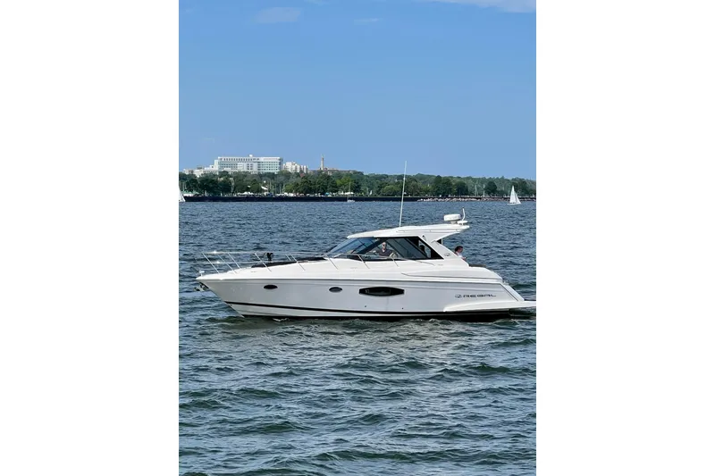 Slide: The Image of 2015 Regal 42 Sport Coupe cruising on a scenic lake with sailboats in the background. - 3