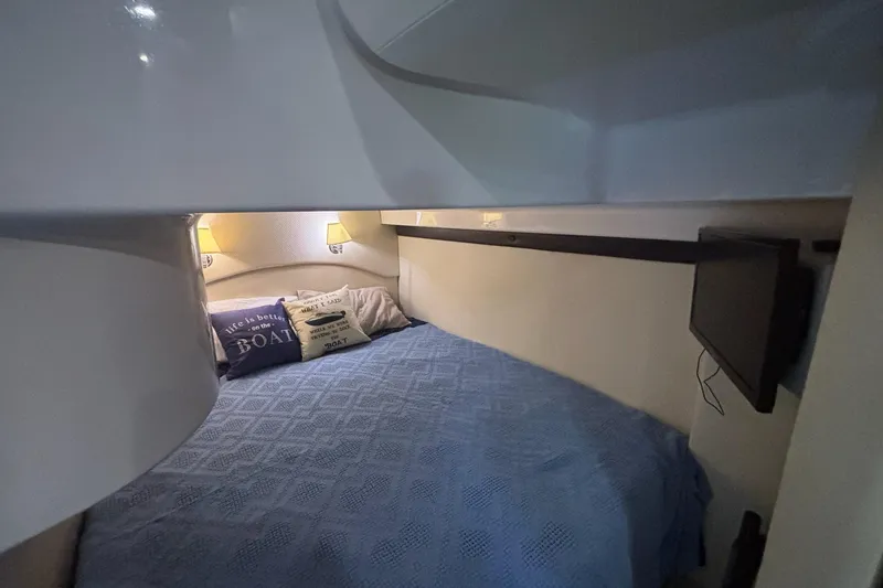 Slide: The Image of Cozy cabin interior of 2015 Regal 42 Sport Coupe with blue bedding and wall-mounted TV. - 32
