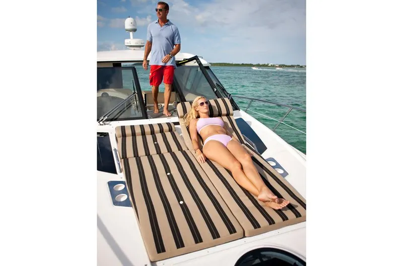 Slide: The Image of Manufacturer Provided Image: 2015 Regal 42 Sport Coupe with sunbathing area on deck, man standing, woman lounging. - 36