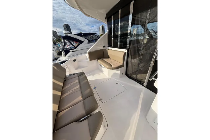 Slide: The Image of 2015 Regal 42 Sport Coupe yacht interior with beige seating and marina view. - 9
