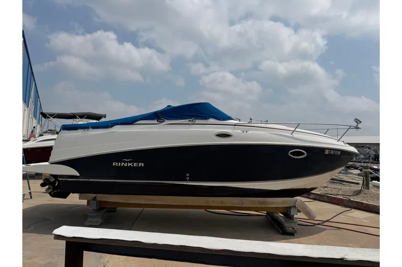 The Image of 2006 Rinker 250 Express Cruiser boat on display under cloudy sky. - 0