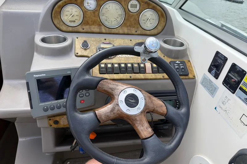 Slide: The Image of 2006 Rinker 250 Express Cruiser dashboard with steering wheel and navigation instruments. - 10