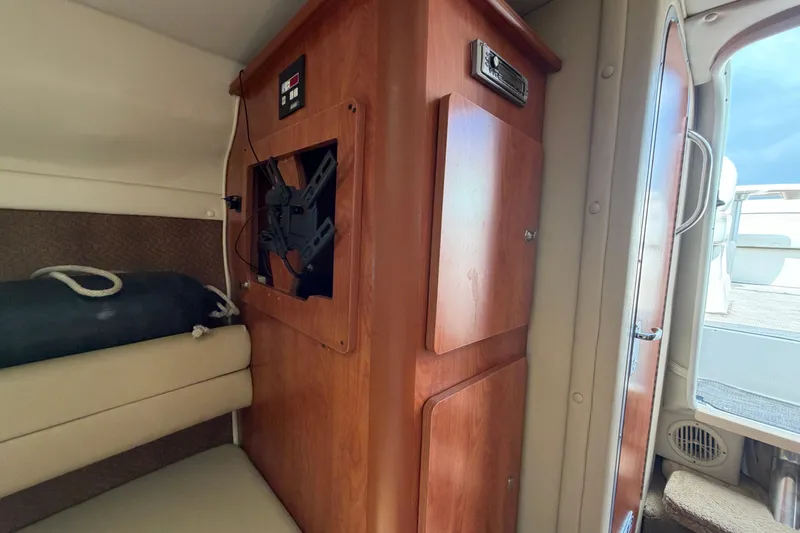 Slide: The Image of Interior of a 2006 Rinker 250 Express Cruiser with wood cabinetry and seating. - 20
