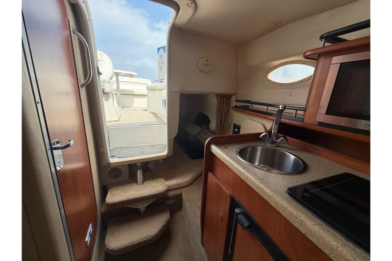 Slide: The Image of Interior of 2006 Rinker 250 Express Cruiser with kitchenette and cabin view. - 23