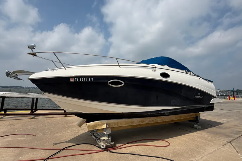 Slide: The Image of 2006 Rinker 250 Express Cruiser on dock, blue and white hull, cloudy sky background. - 4