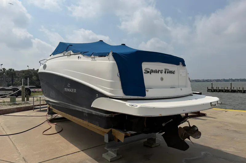 Slide: The Image of 2006 Rinker 250 Express Cruiser boat docked with blue cover, named "Spare Time." - 5