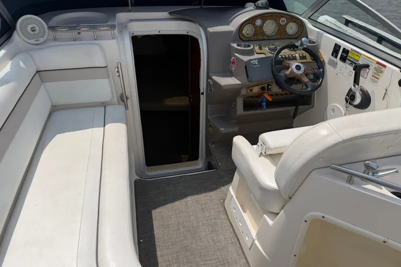 Slide: The Image of 2006 Rinker 250 Express Cruiser interior with helm, seating, and cabin entrance. - 6