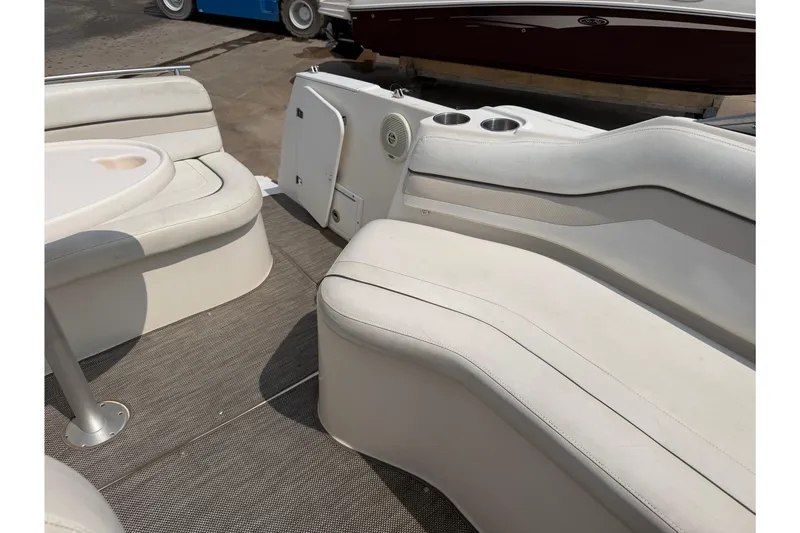 Slide: The Image of 2006 Rinker 250 Express Cruiser interior with white seating and table. - 9