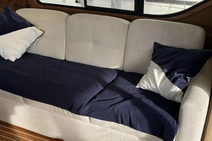 Slide: The Image of Beige sofa with navy and white pillows inside a 1990 Cooper Prowler Sedan. - 12
