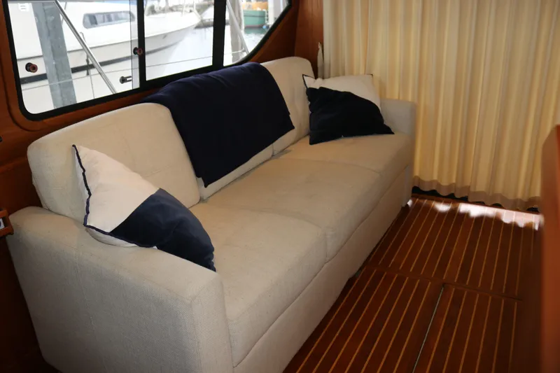 Slide: The Image of Luxurious boat interior with beige sofa, navy pillows, and wooden flooring. - 30