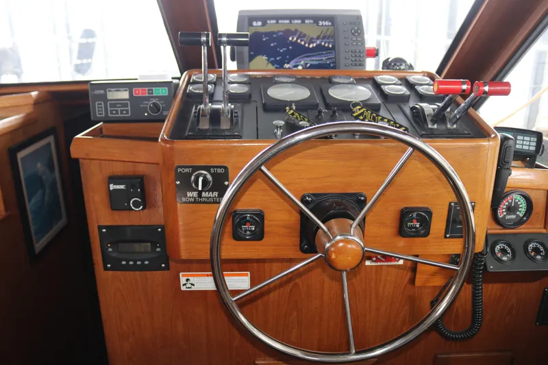 Slide: The Image of Boat cockpit with wooden steering wheel, navigation controls, and electronic displays. - 36