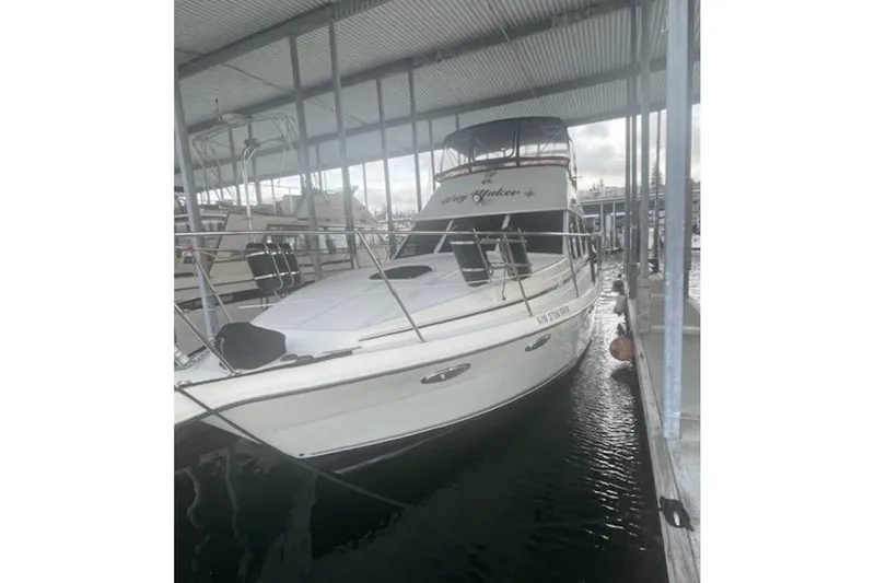 Slide: The Image of A boat docked in a marina under a metal roof, reflecting on the water. - 4