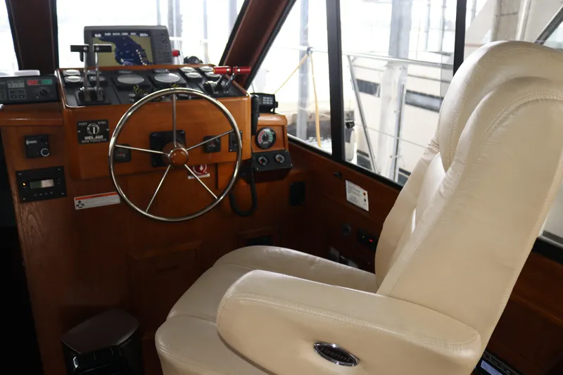 Slide: The Image of Boat cockpit with steering wheel, control panel, and beige captain's chair. - 43