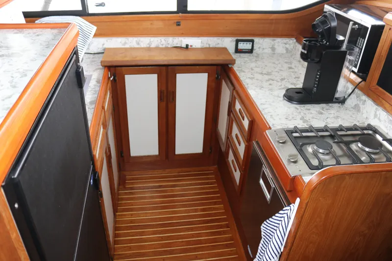 Slide: The Image of Compact kitchen area in a 1990 Cooper Prowler Sedan with stove, fridge, and coffee maker. - 48